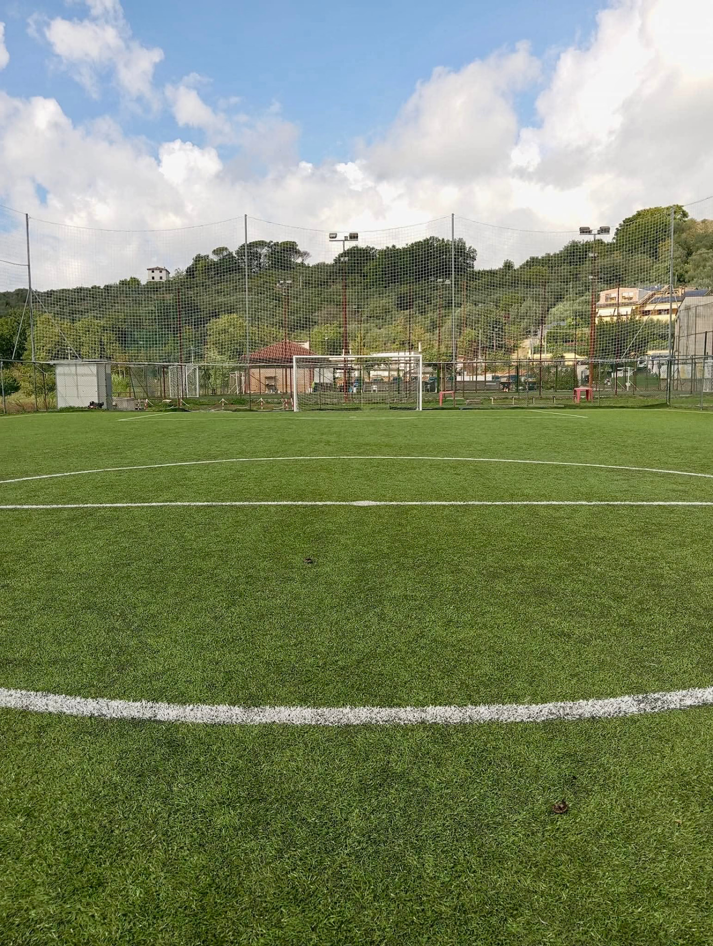 Campo da calcio in erba sintetica con vista sulle colline
