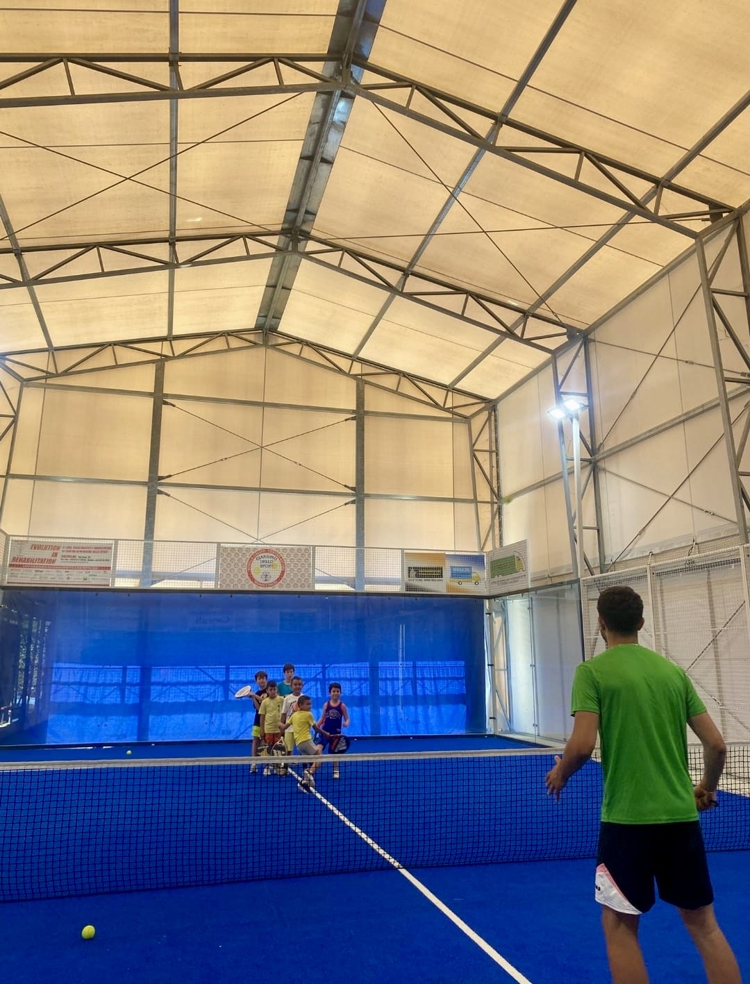 Ragazzi durante un'attività di padel sul campo coperto