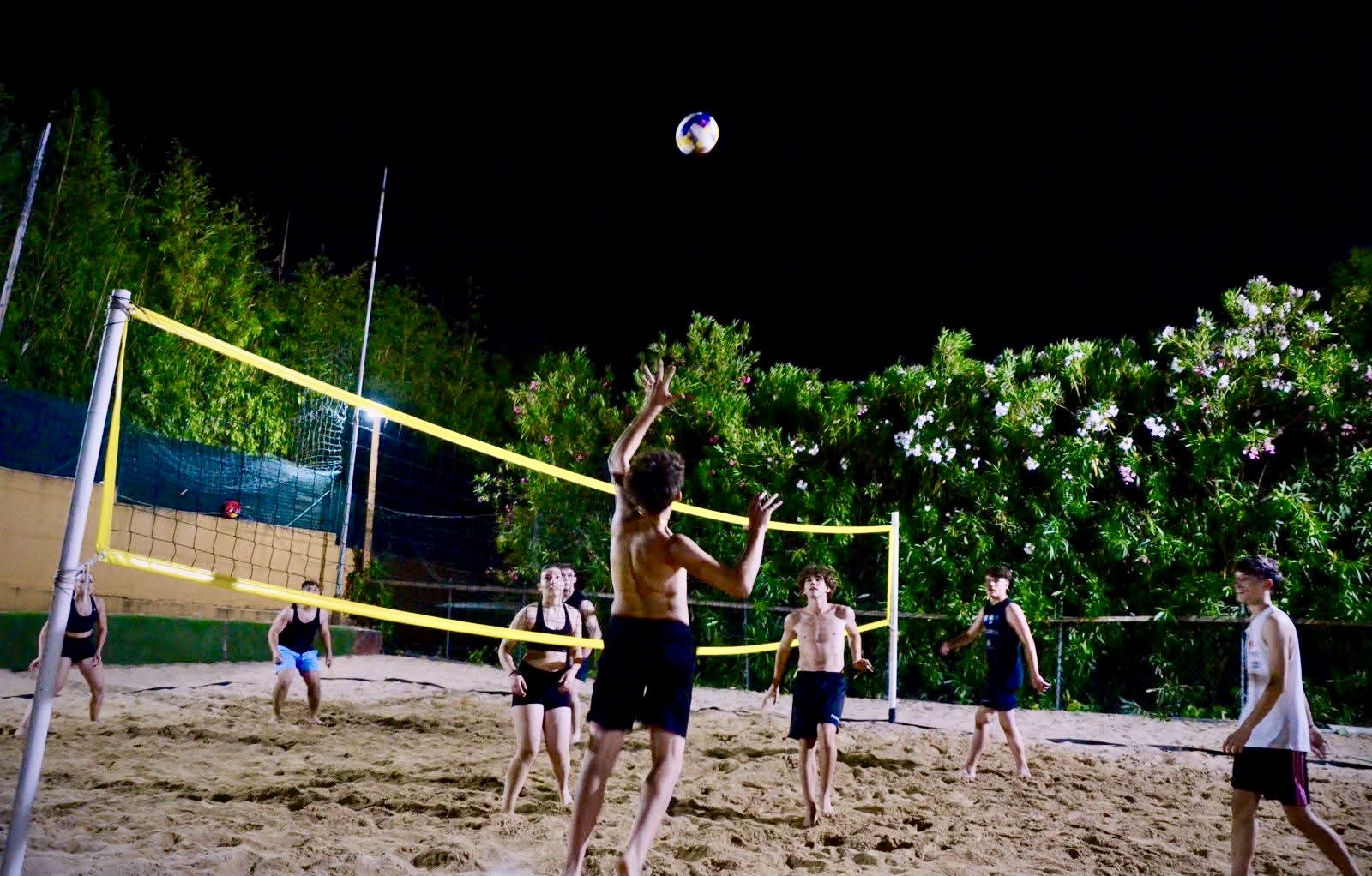 Partita di beach volley in notturna sul campo in sabbia