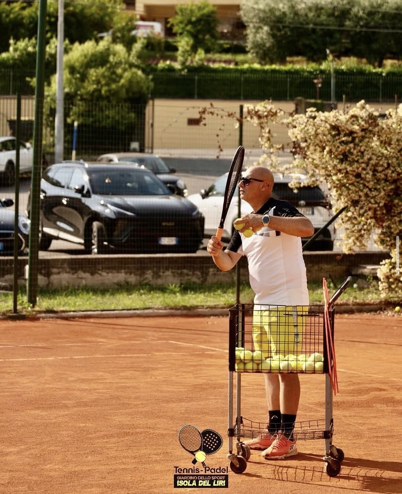 Il maestro di tennis durante una lezione sul campo in terra battuta